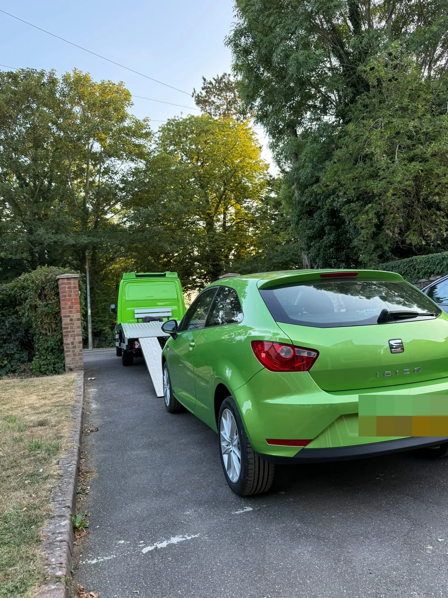 Green Seat Ibiza waiting behind the flatbed in a lane