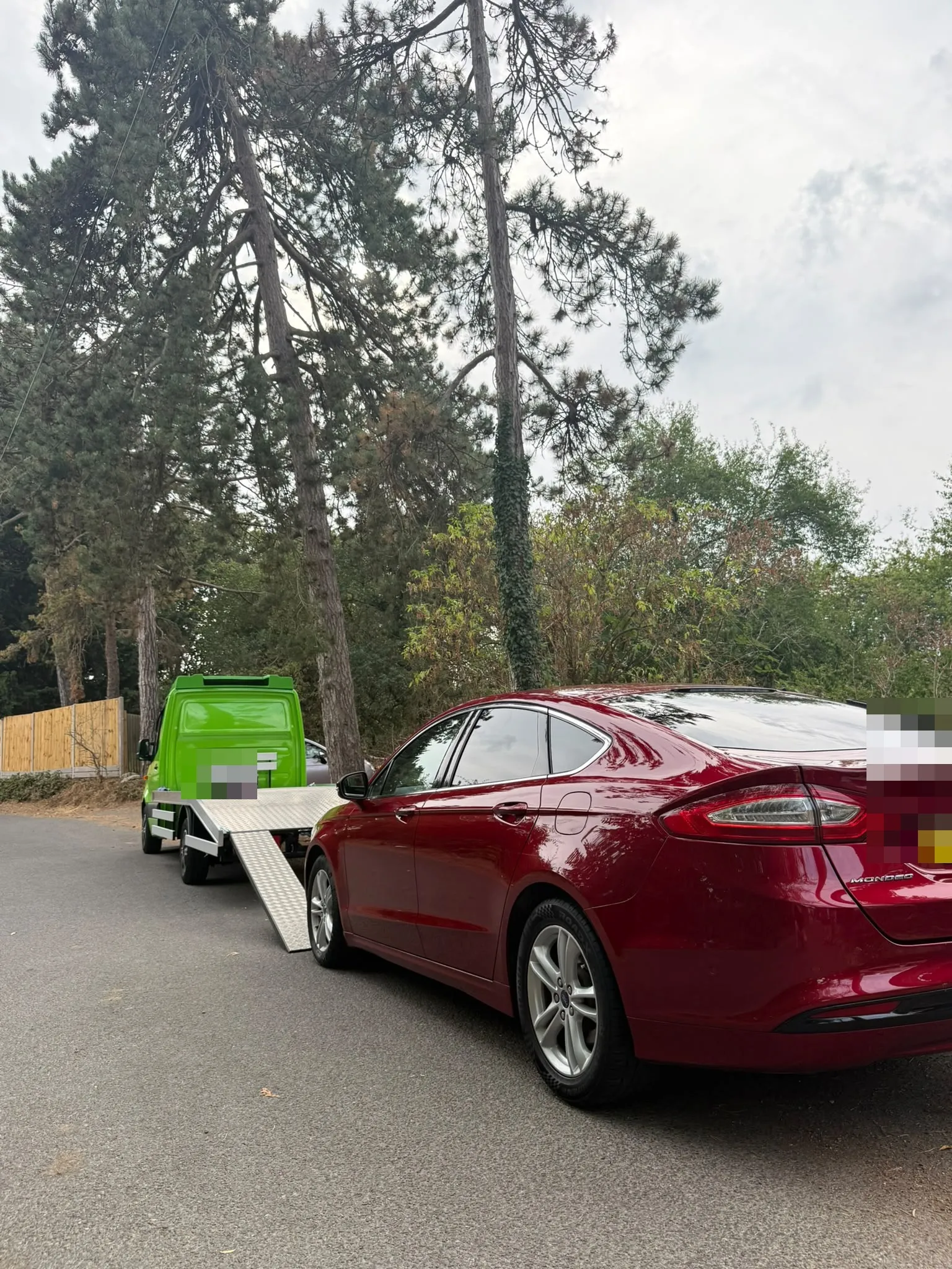 Red Ford Mondeo parked behind the flatbed with its ramp down